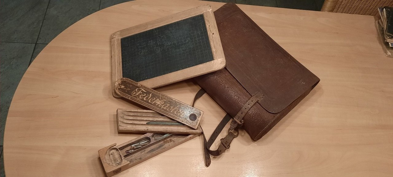 Tisch mit Schiefertafel, Federkasten und Lederranzen